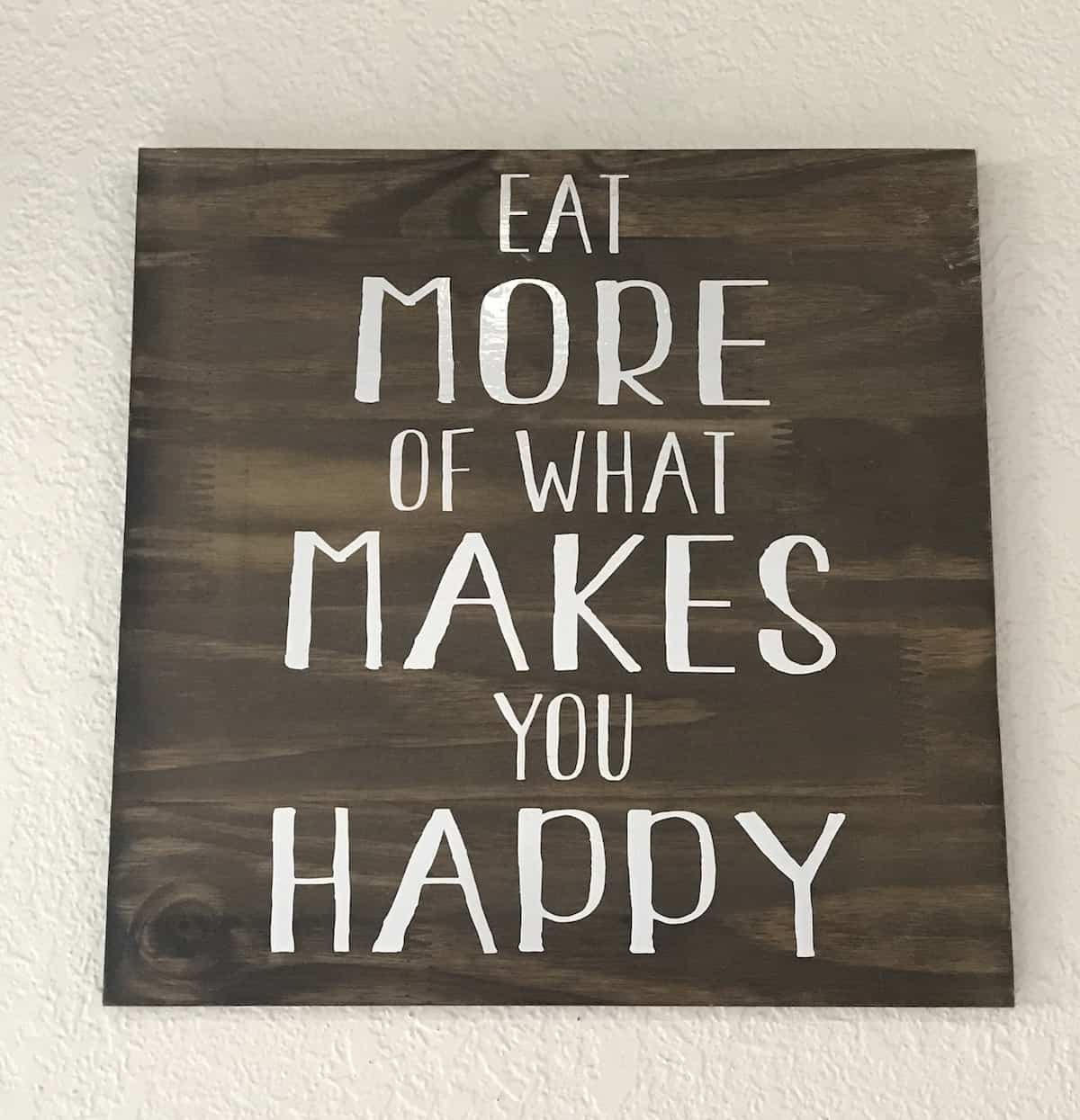 Sign on wall in The Yard restaurant, Eat More of What Makes You Happy
