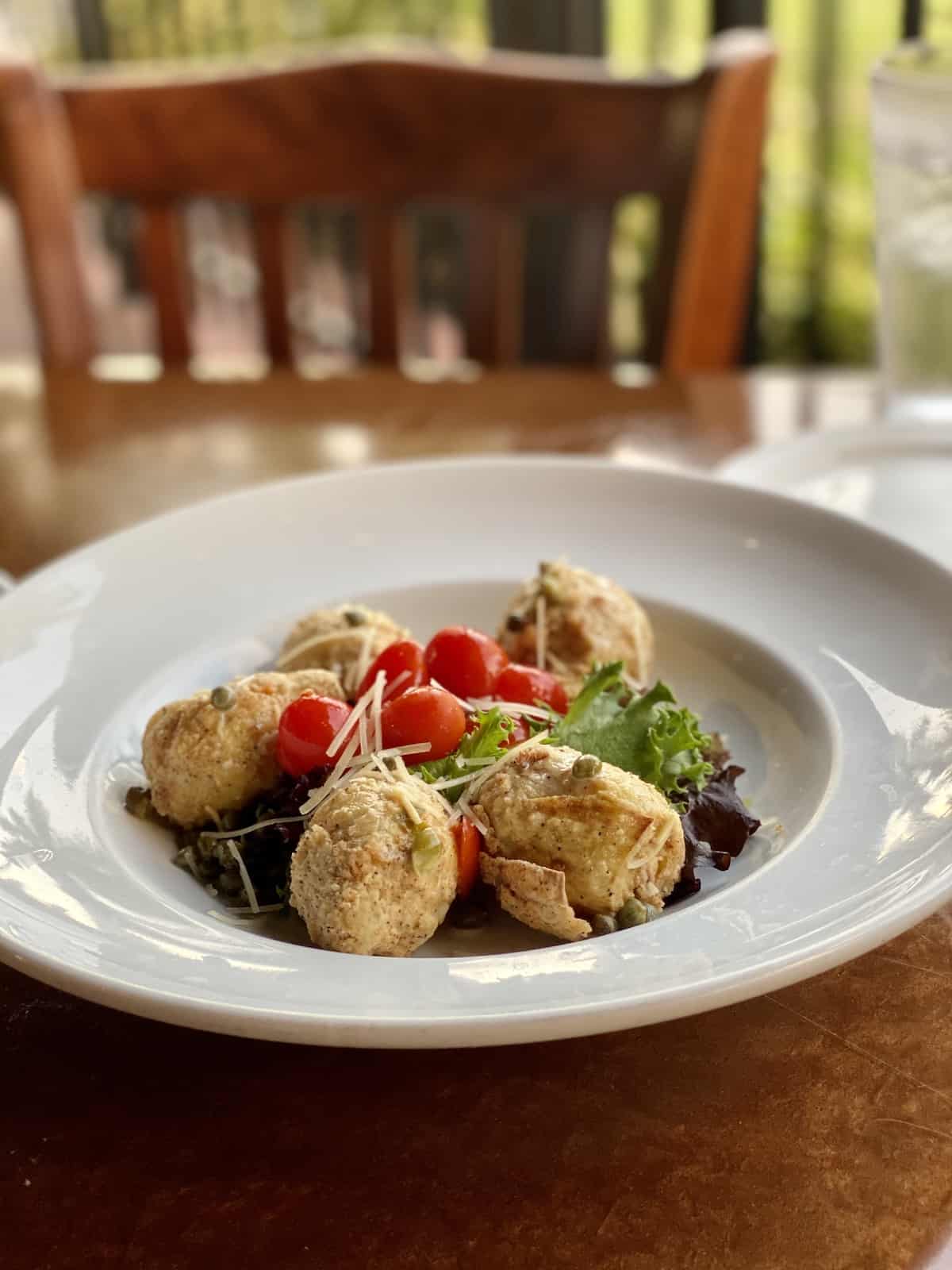 Fried artichokes with salad on white plate at Mattison's, one of the best Bradenton restaurants.