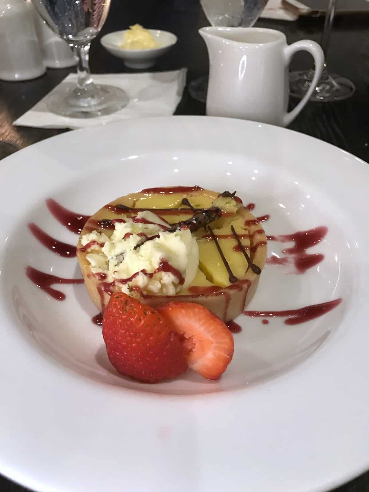 Lemon tart with strawberries in white bowl.