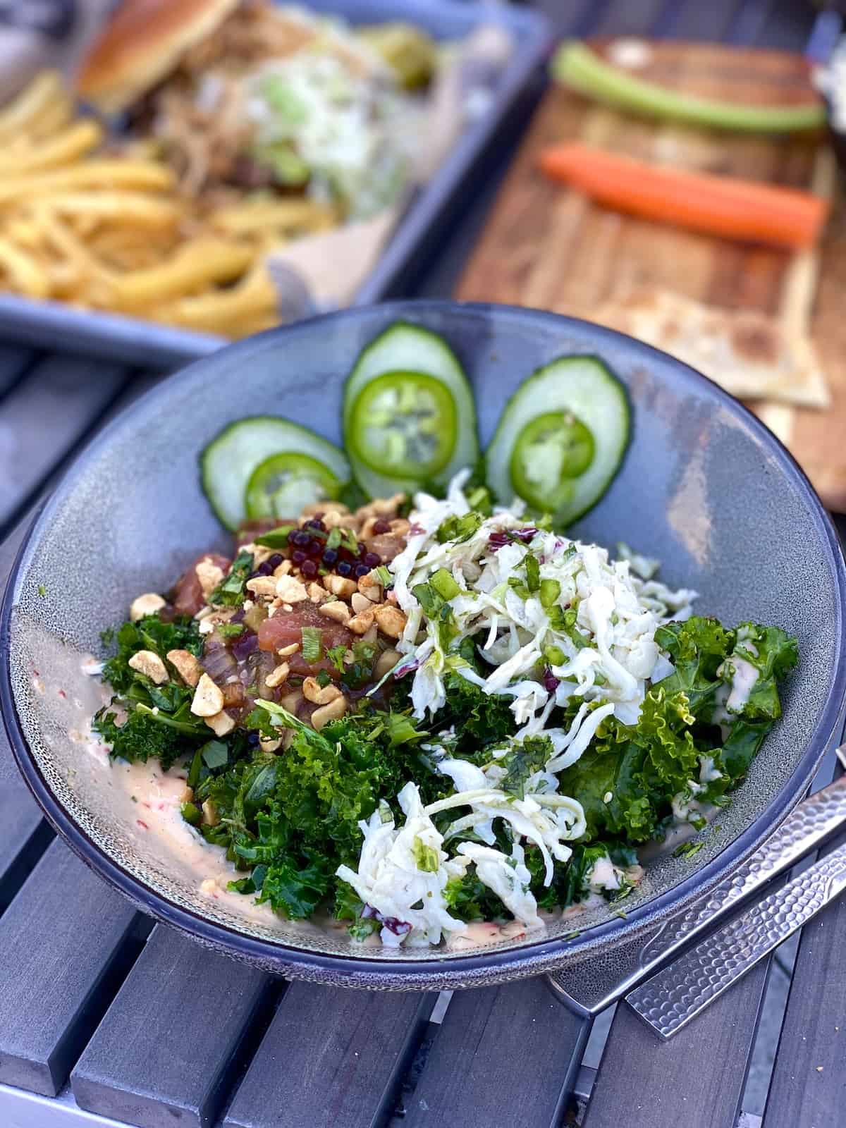 Fresh raw tuna and kale salad with veggies and nuts.