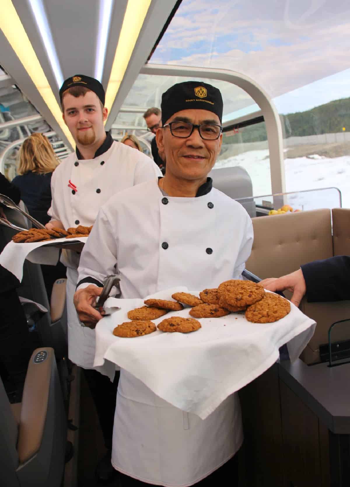 Men serving cookies on a train.