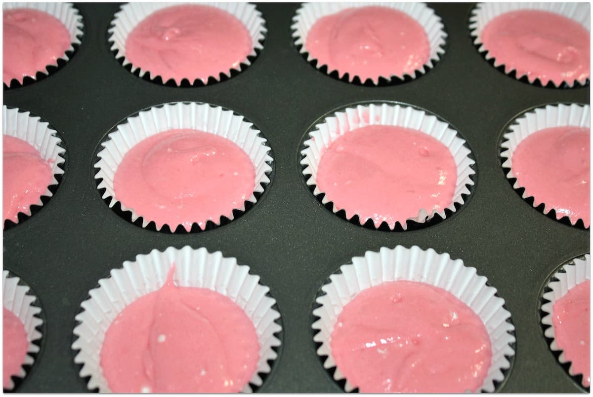 Pink cupcakes in liners before baking.