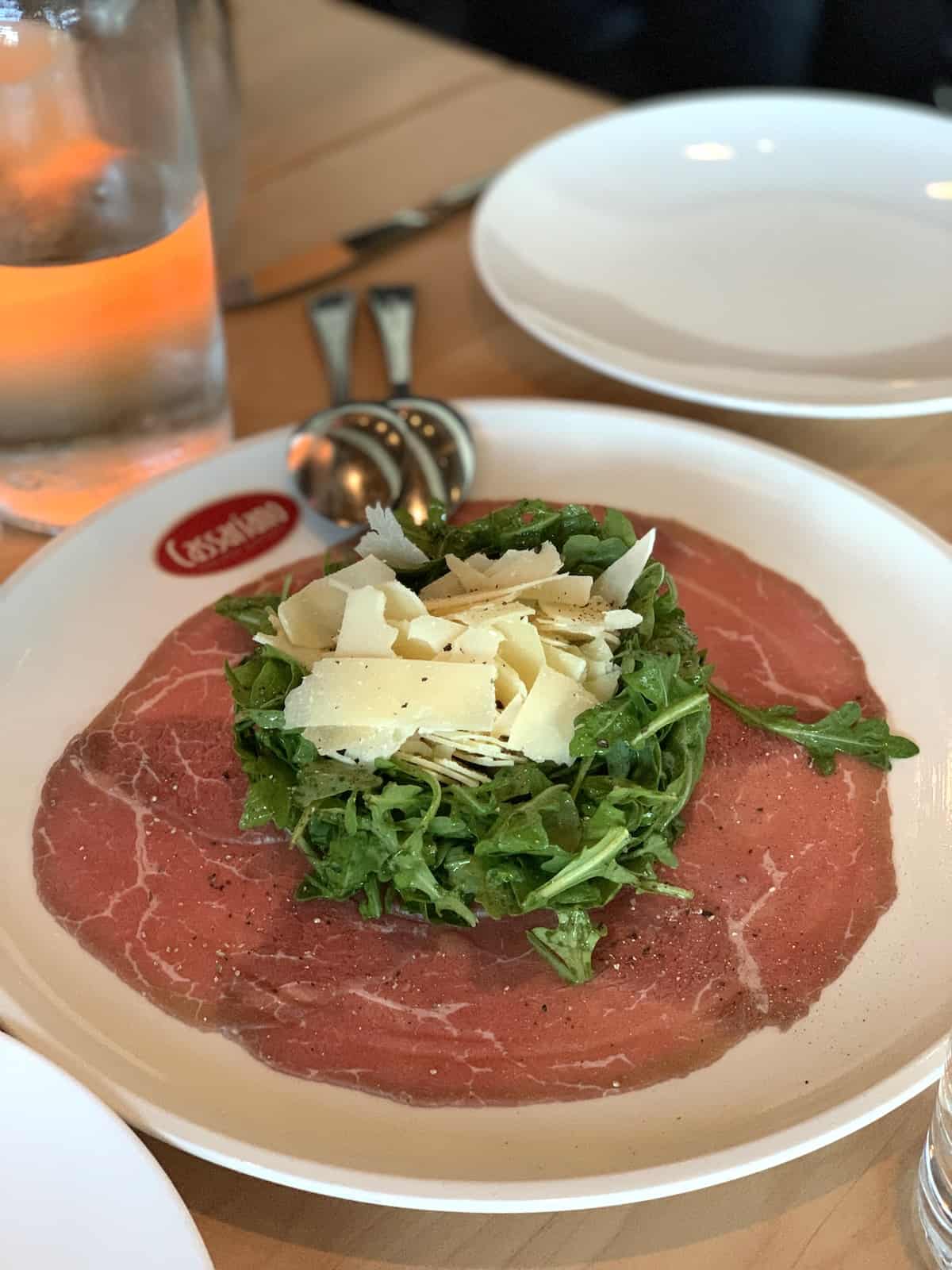 Carpaccio di Carne with parmesan cheese and Cassariano restaurant.