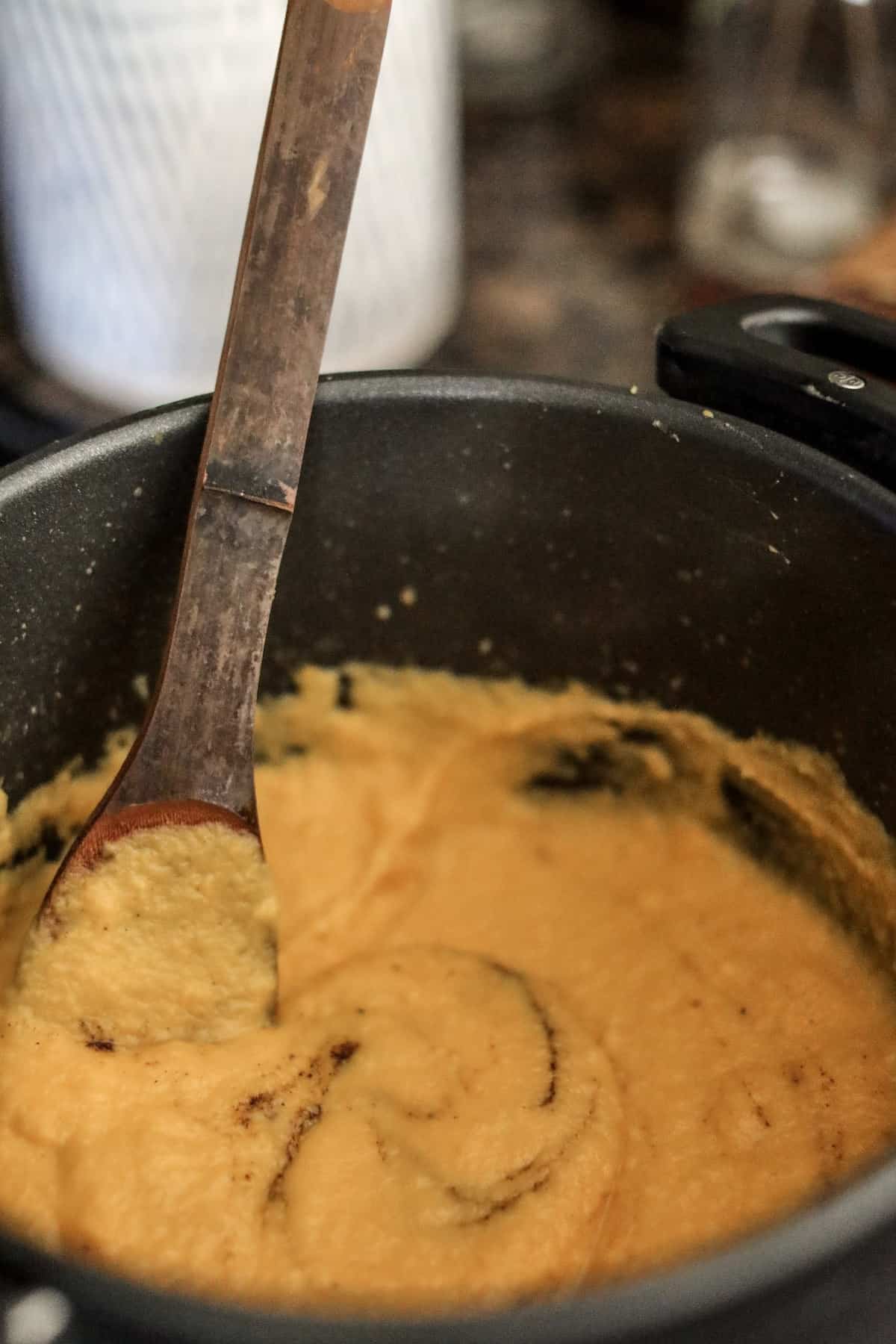 Stirring butternut squash pasta sauce.