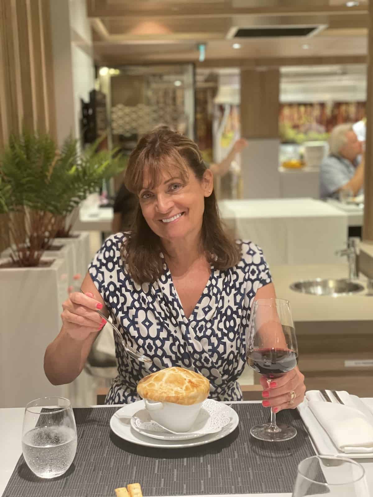 Woman dining with a glass of red wine.