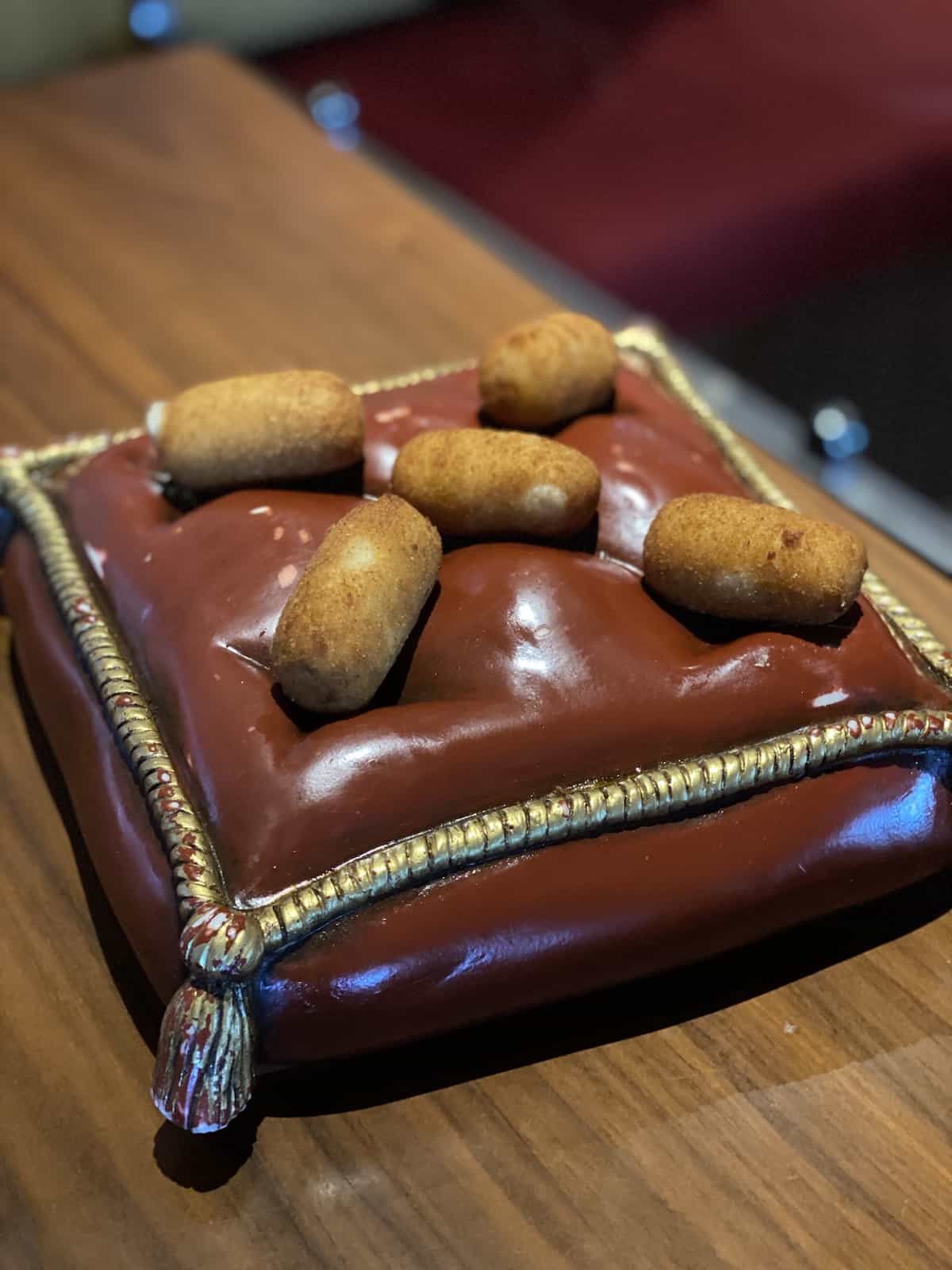Chicken Croquettes on a red and gold tray.