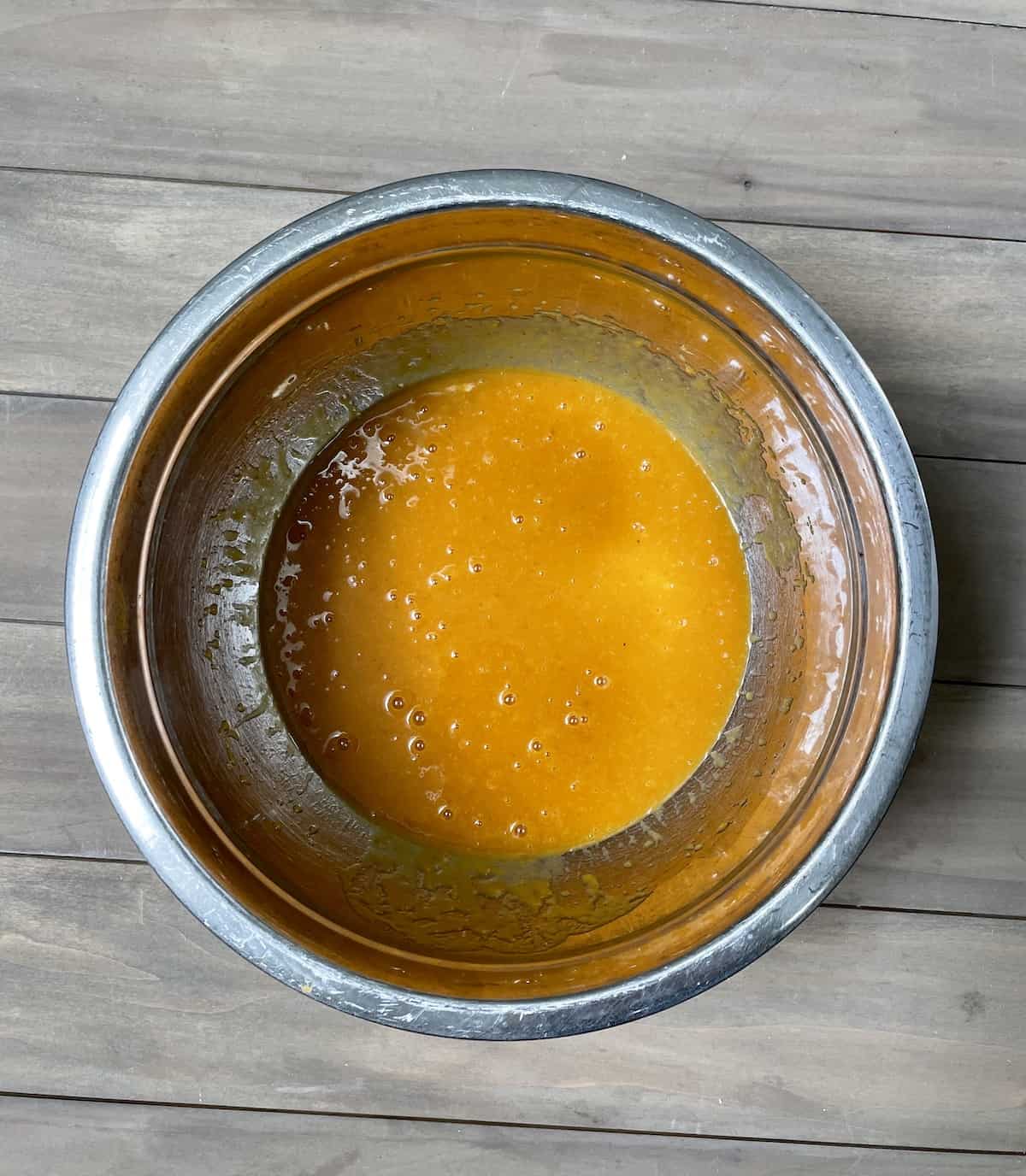 Pumpkin cake mix in stainless bowl.
