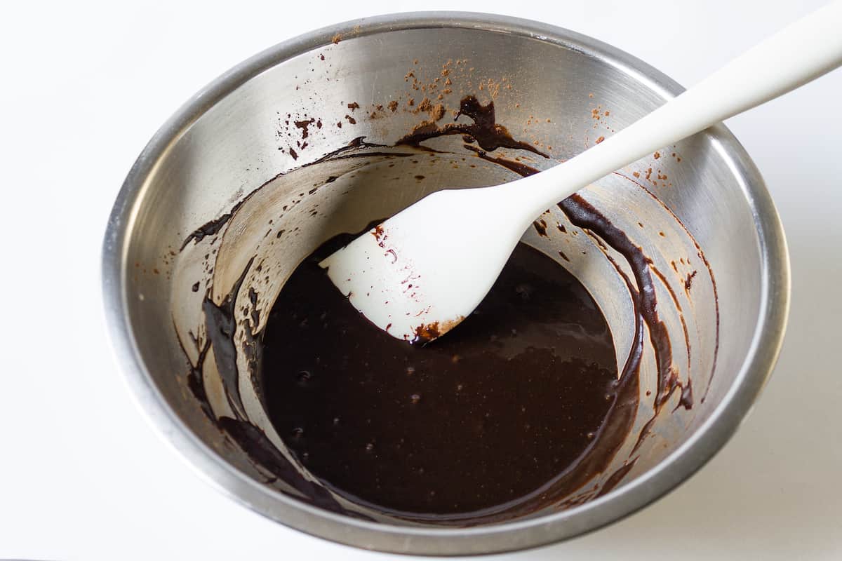 Powdered sugar, cocoa powder, sea salt, cinnamon, coconut oil, water, and vanilla extract in a large bowl mixed.