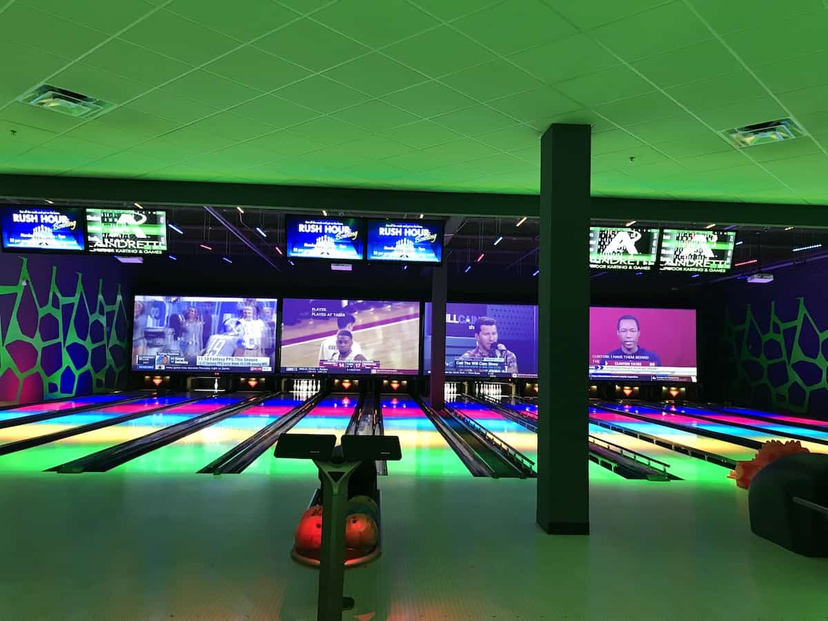 Bowling Alley with green light and LED screens.