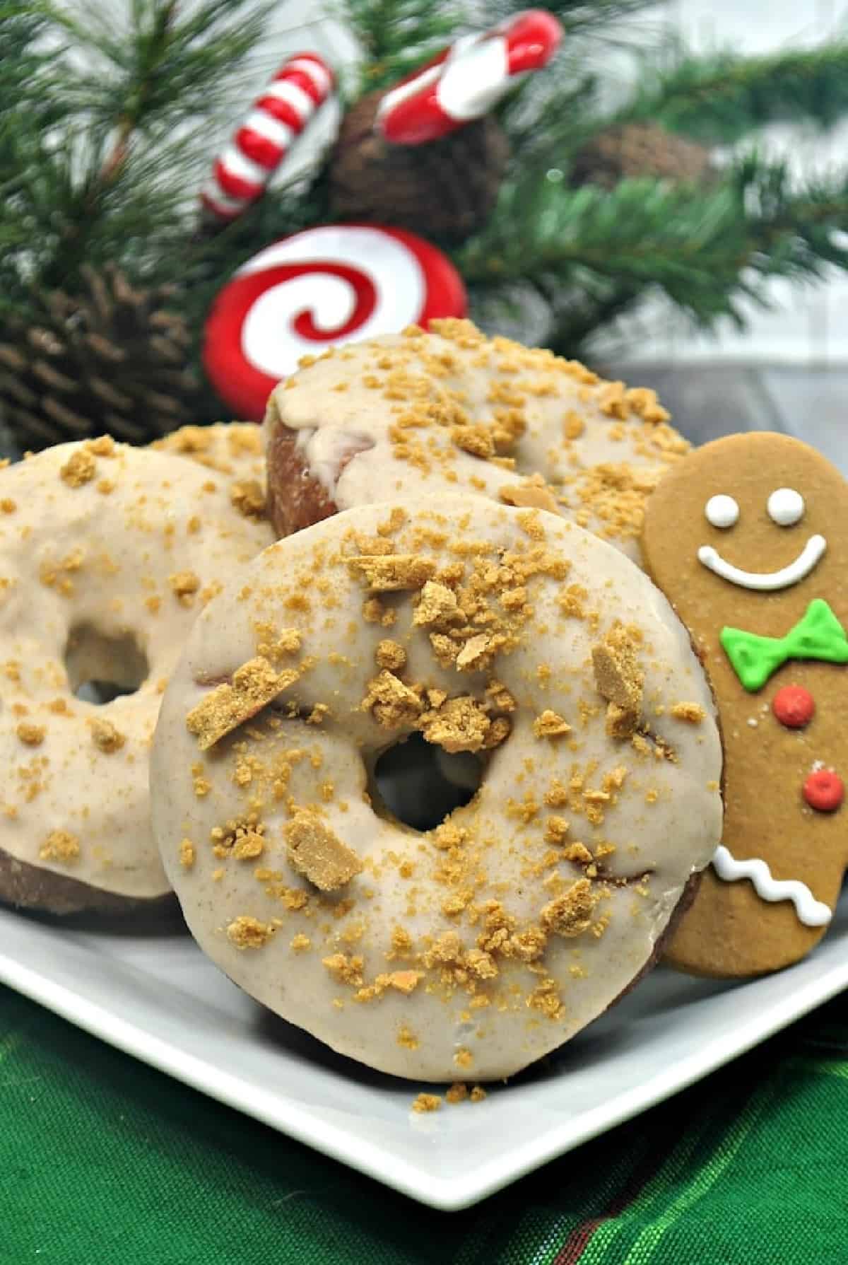 Christmas gingerbread donuts with a gingerbread man on a white plate.