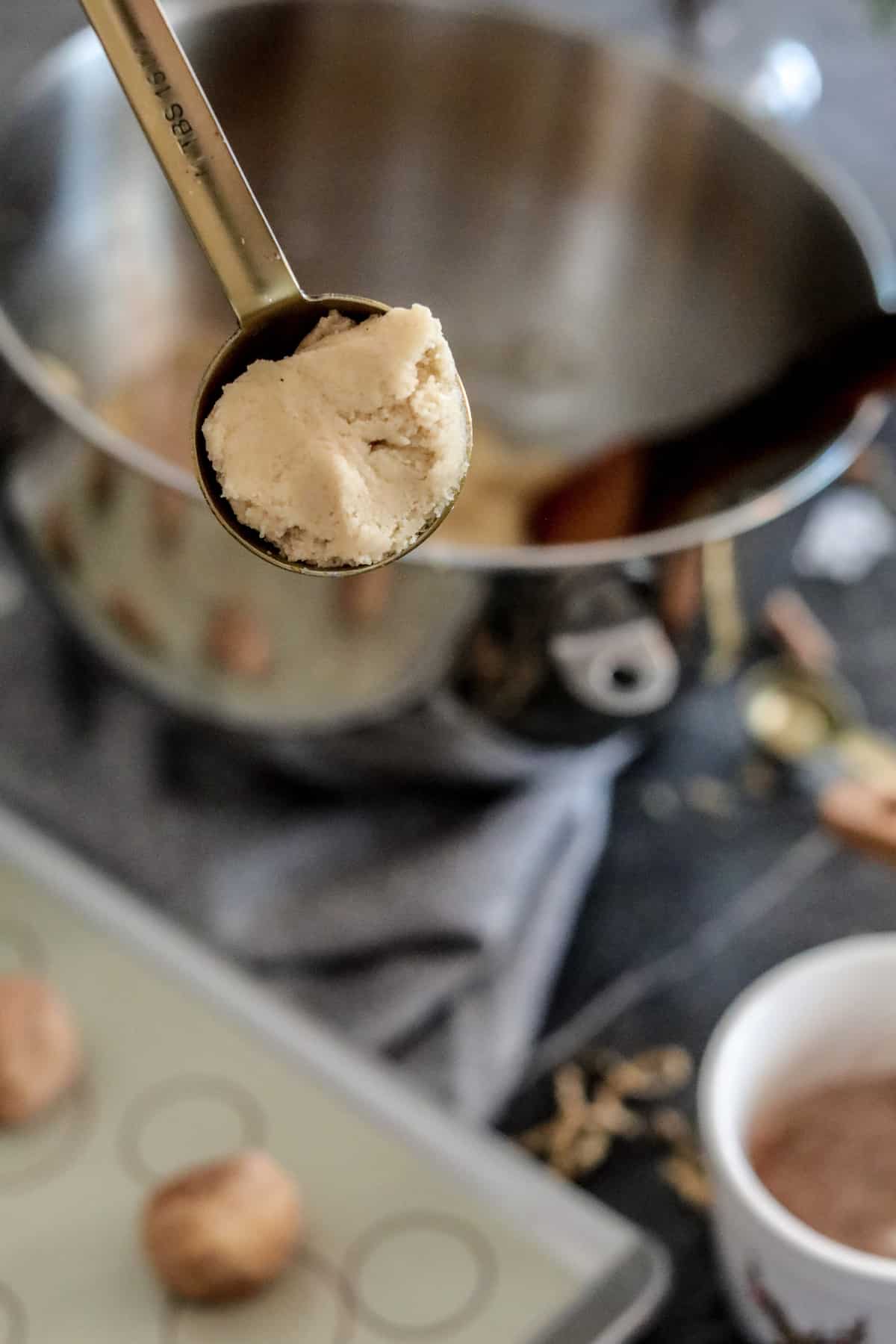 Cookie dough in a measuring spoon.