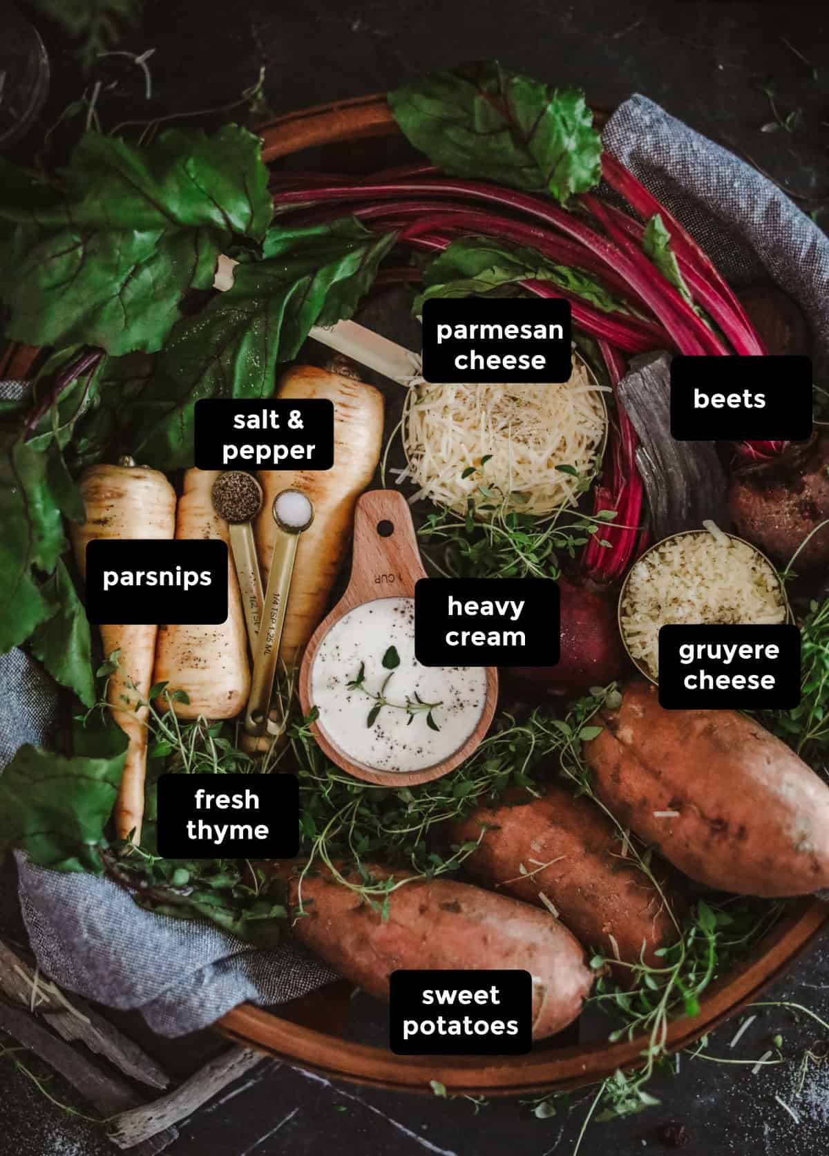 Parsnips, sweet potatoes, beets, cheeses, cream, salt, pepper, and thyme in a wood bowl.