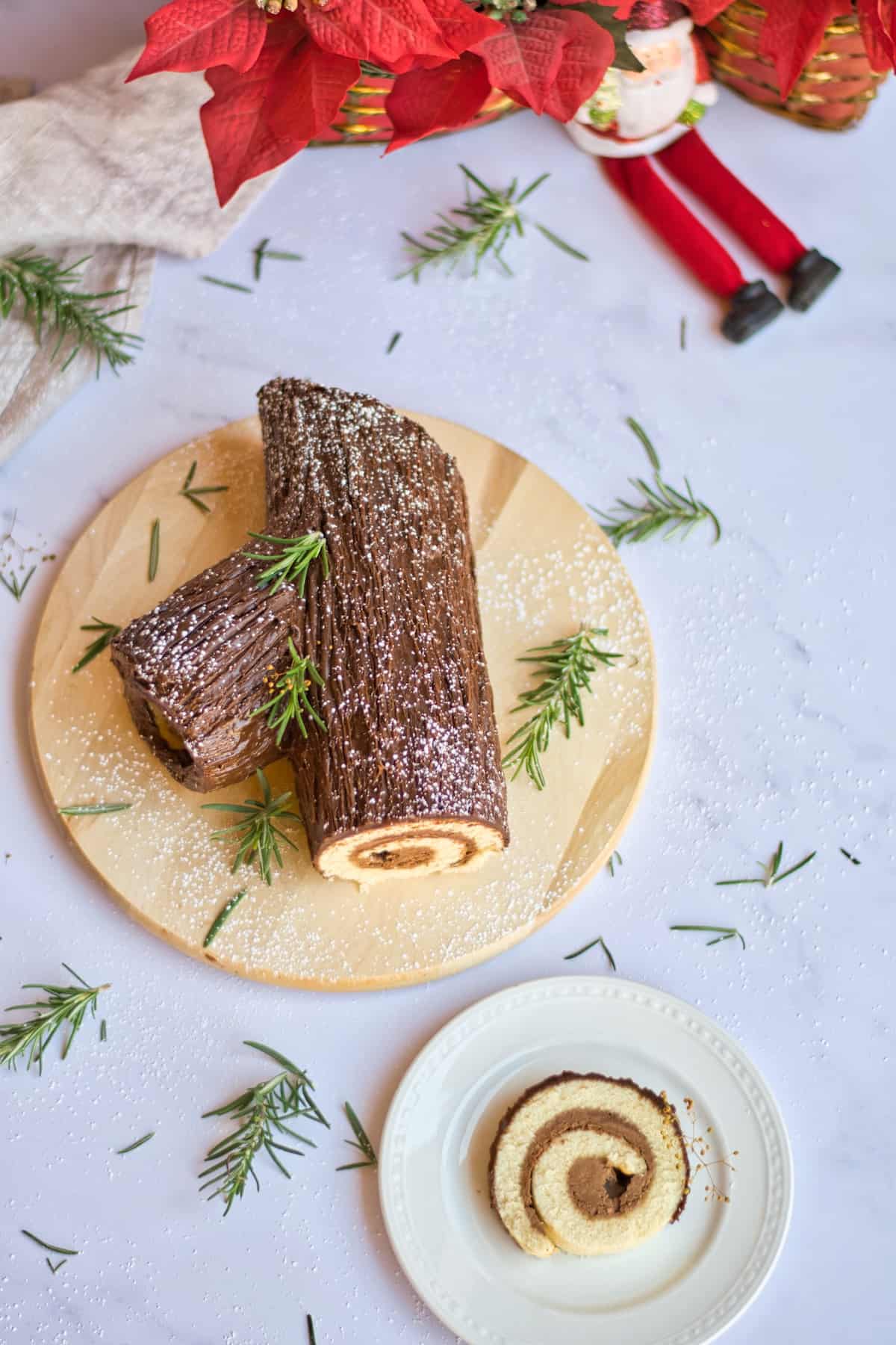 Chocolate rolled cake to look like yule log from above with Christmas decor.