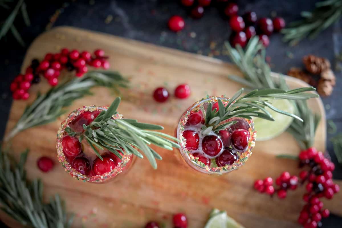 Flat lay shot of cranberry mimosa cocktails with rosemary sprig.