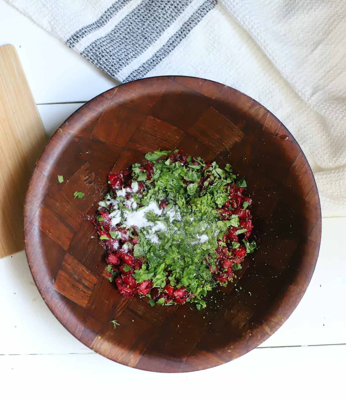 Cranberry salsa ingredients in a wood bowl.