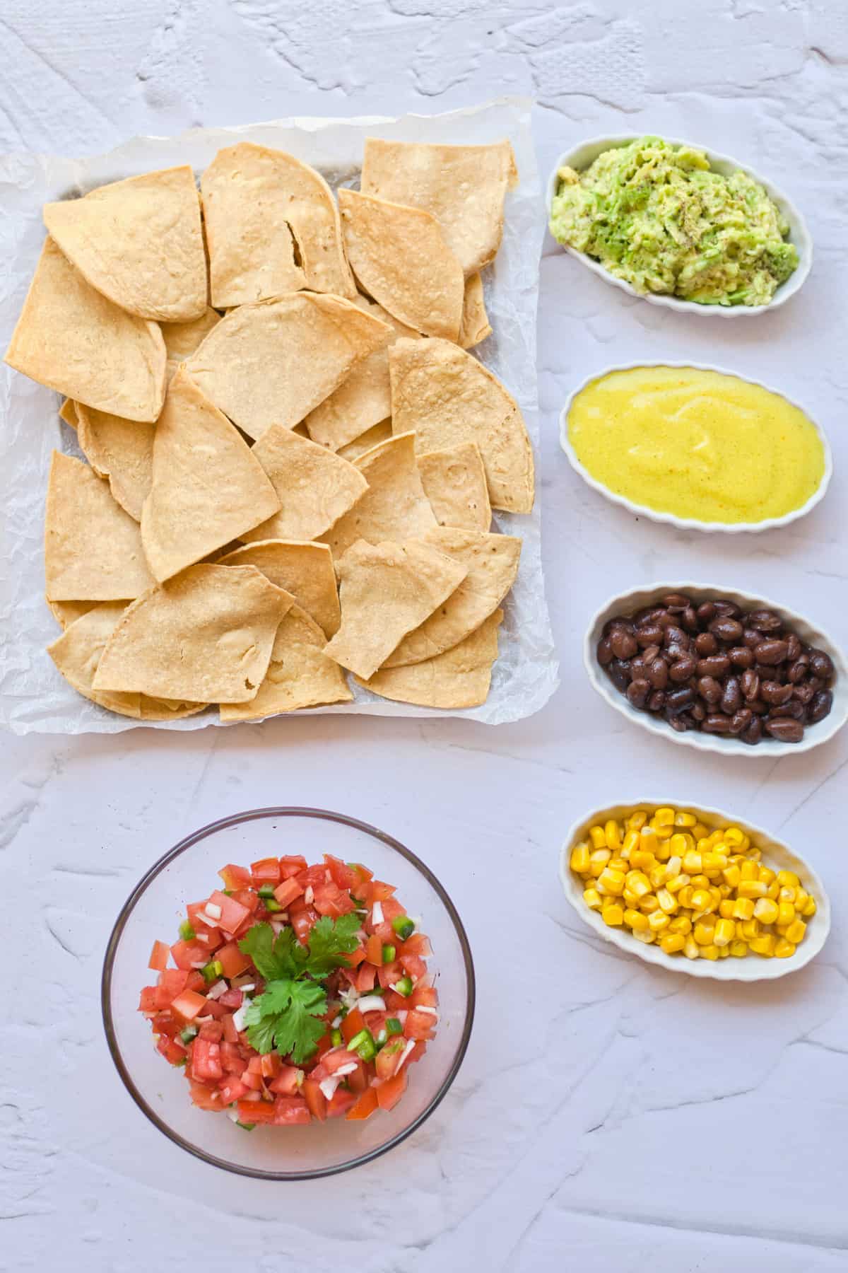 Tortilla chips with salsa, corn, black beans, and guacamole.