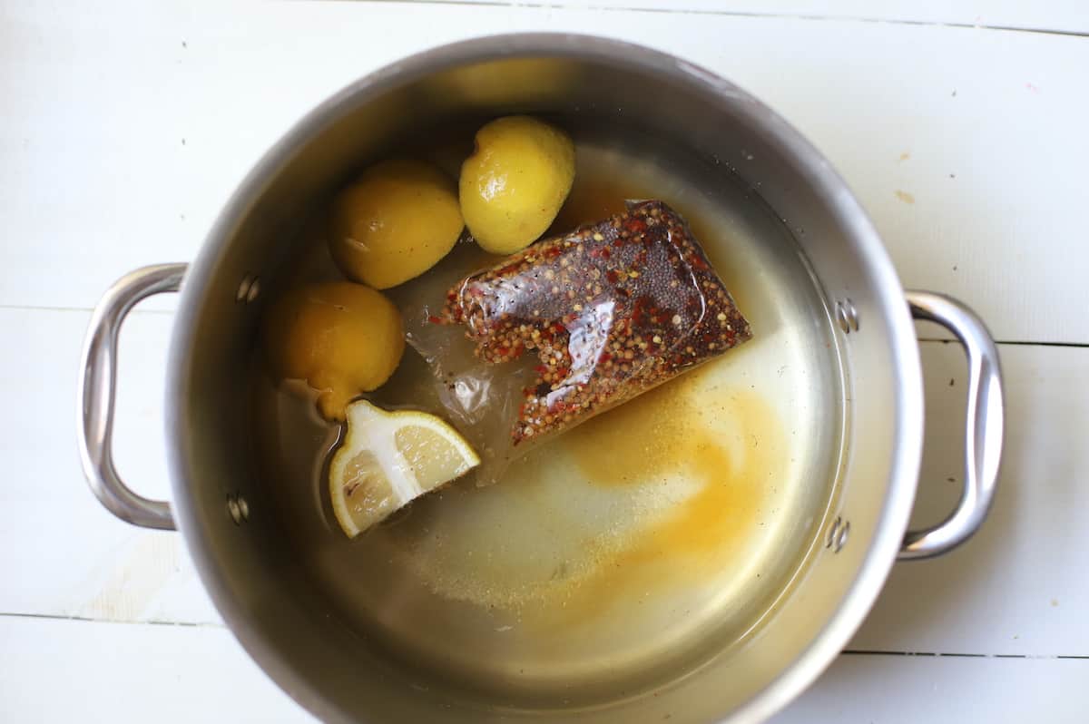 Pot of water with seasoning and lemons.