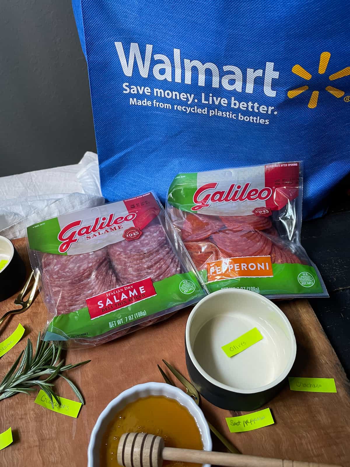Walmart bag, a package of salame, and a package of pepperoni, bowls marked for extras.