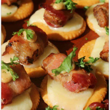 Bacon wrapped chicken bites on crackers.
