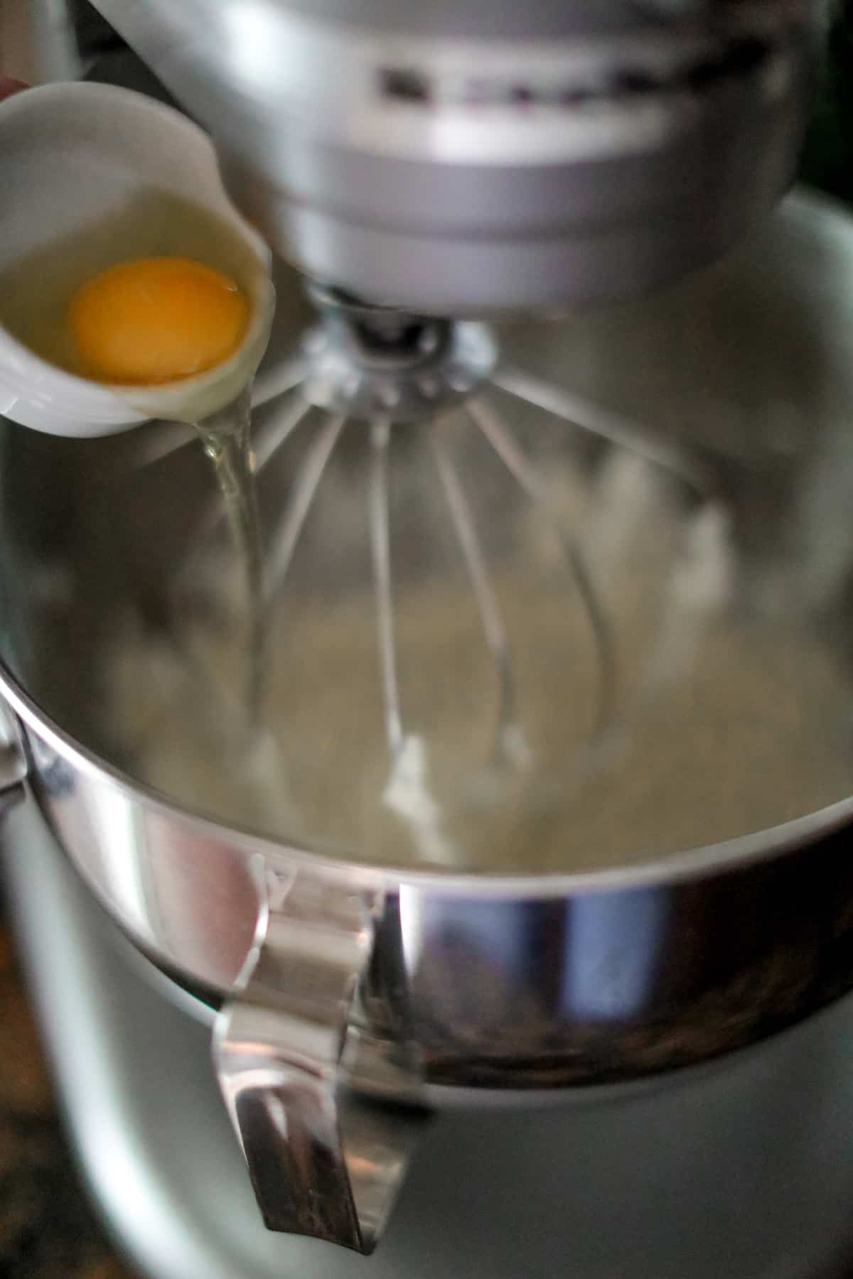 Egg going into large bowl of stand mixer.