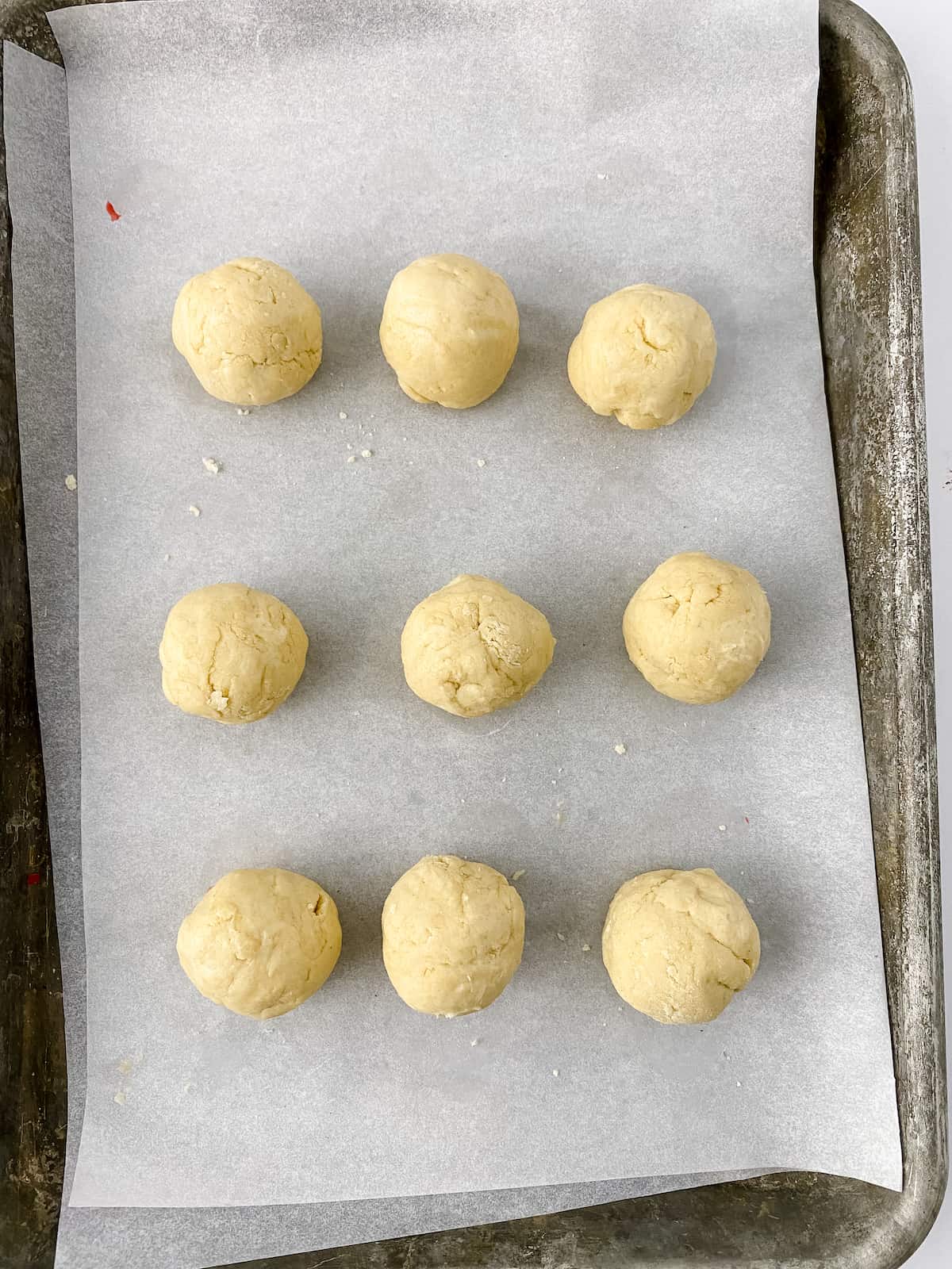 Cookie dough bites in cookie sheet on waxed paper.