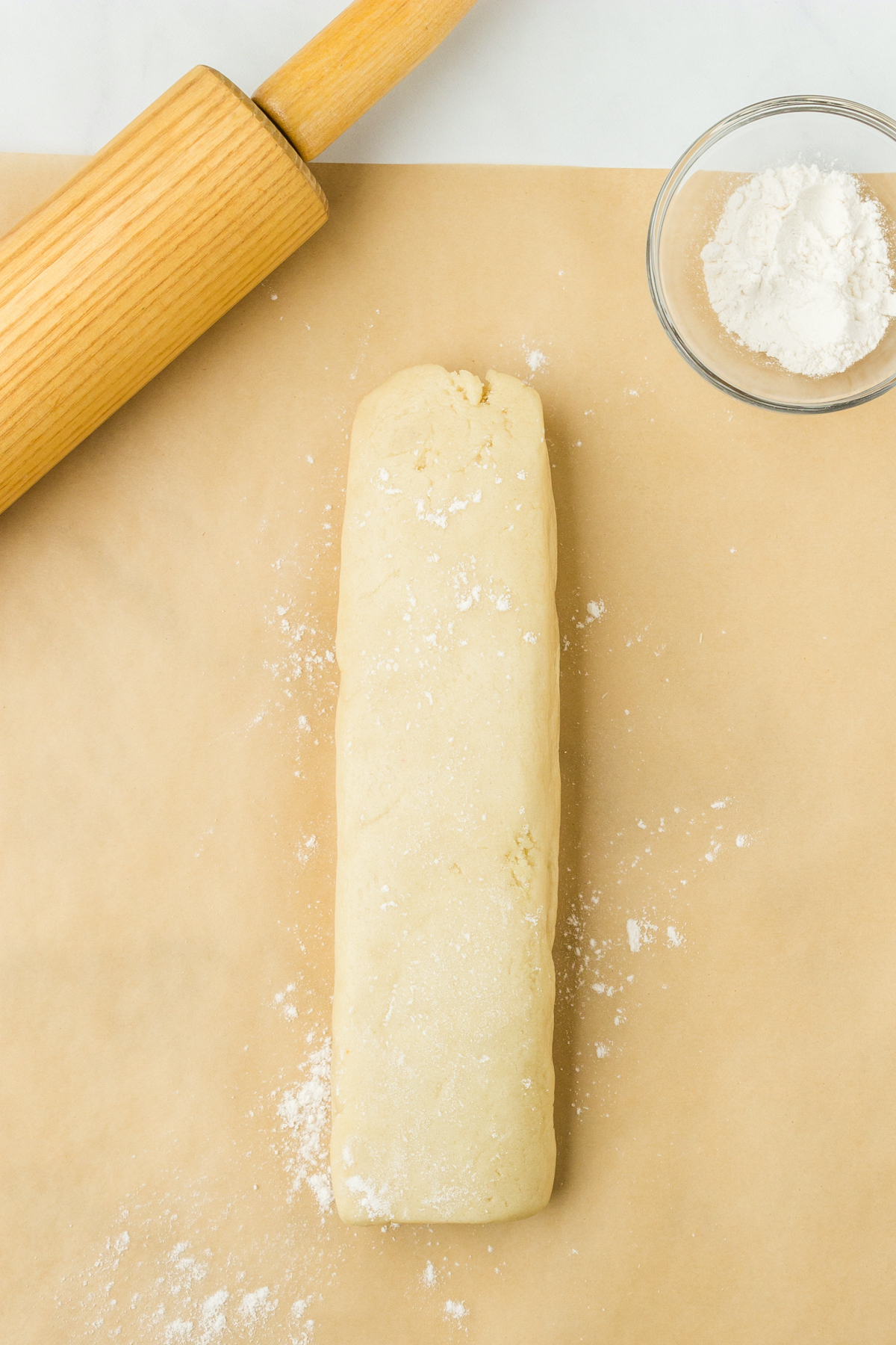 Sugar cookie dough roll on parchment paper.