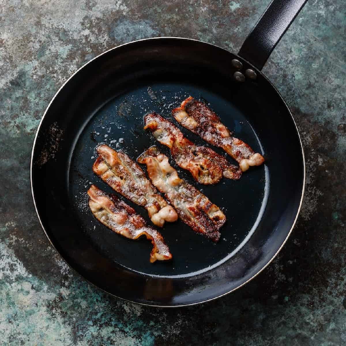 Bacon frying in a pan.