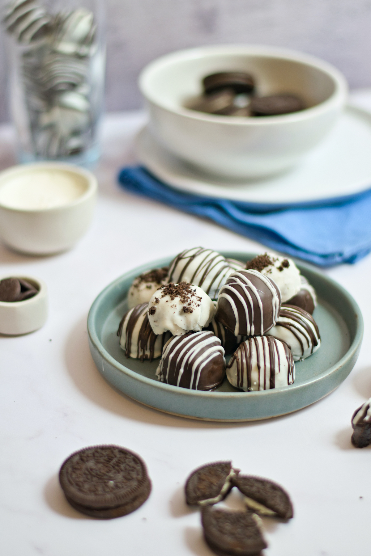 OREO Cake Balls on a teal plate on a white table.