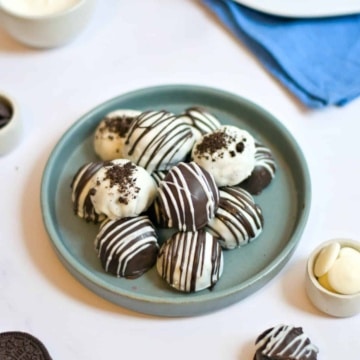 OREO cookie balls truffles on a teal plate on a white table.