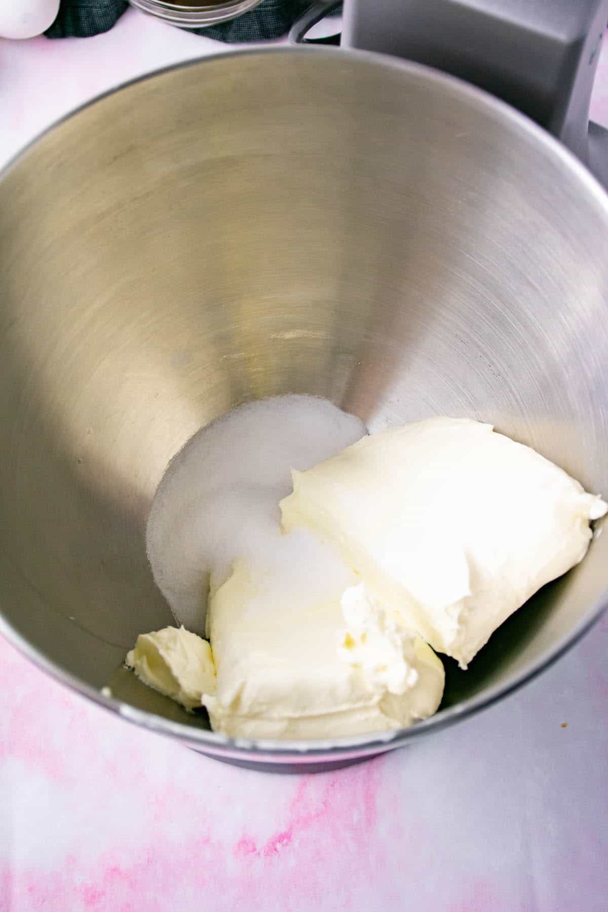Sugar and cream cheese in a stainless bowl on a marble table.