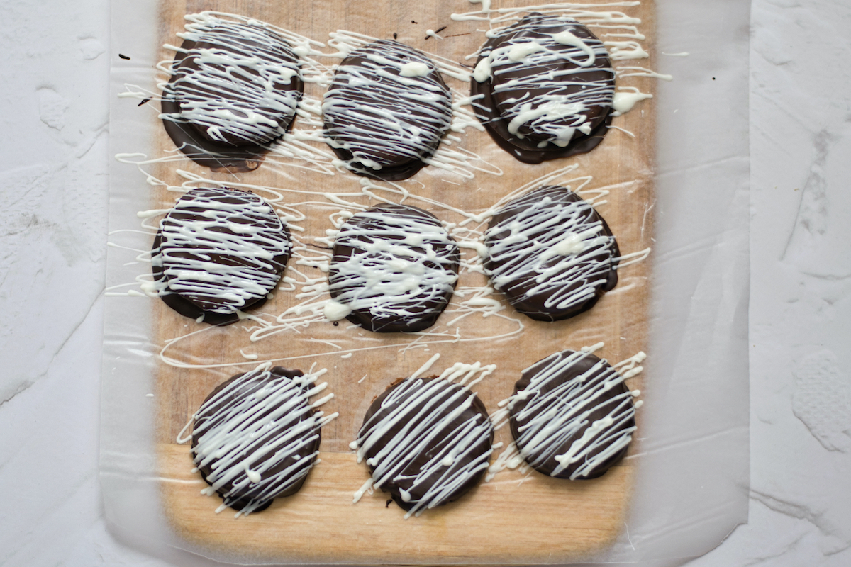 Chocolate dipped cookies with white chocolate drizzle.