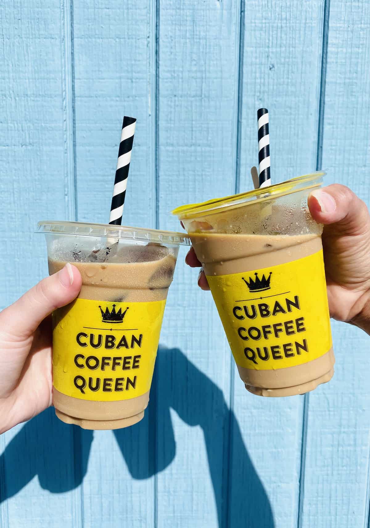 Two plastic cups with brown liquid that say Cuban Coffee Queen.
