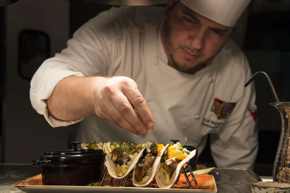 Chef plating food at Antojitos restaurant in CityWalk Orlando Florida.