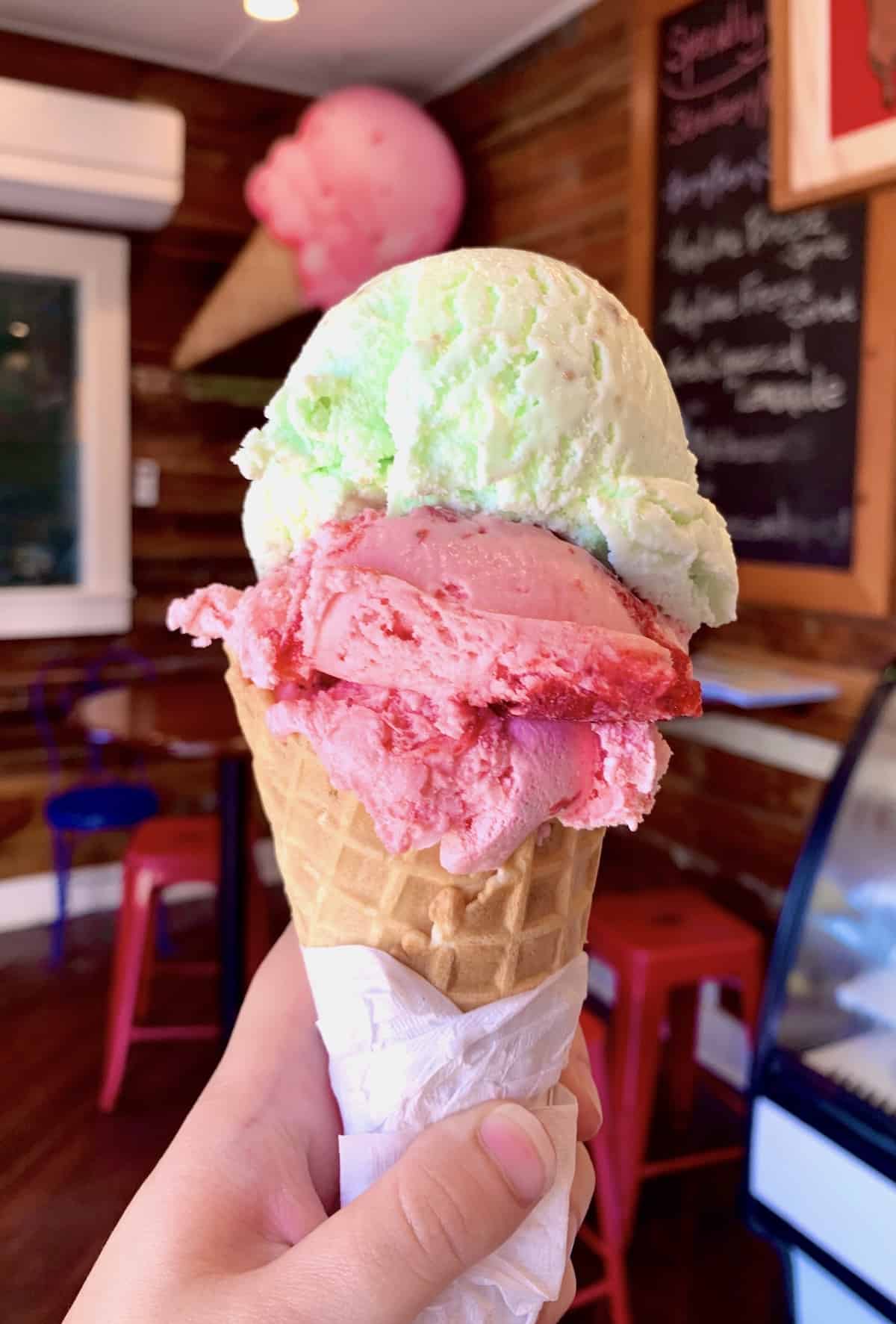 Waffle cone with strawberry and key lime ice cream.