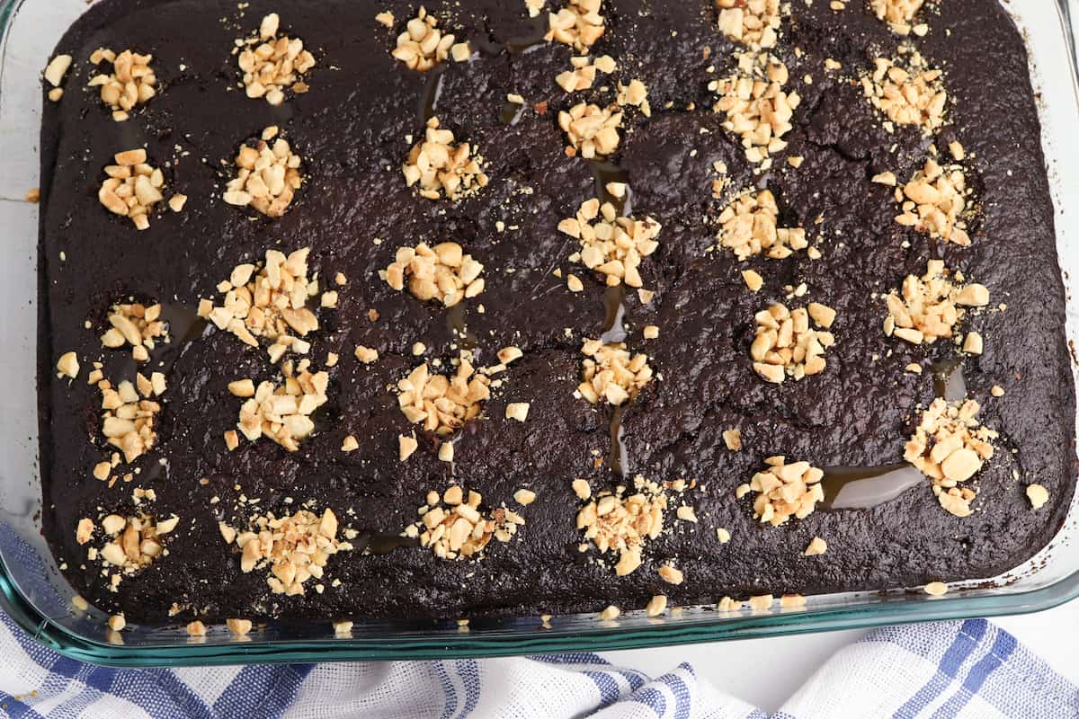 Chocolate cake with caramel and peanuts in holes.