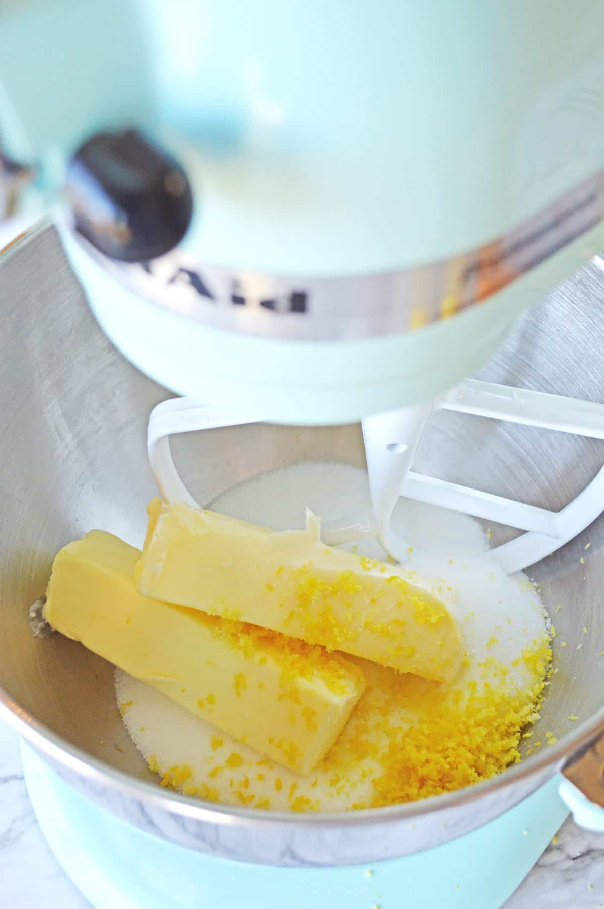 Butter, sugar, vanilla, and lemon in mixer before mixing.