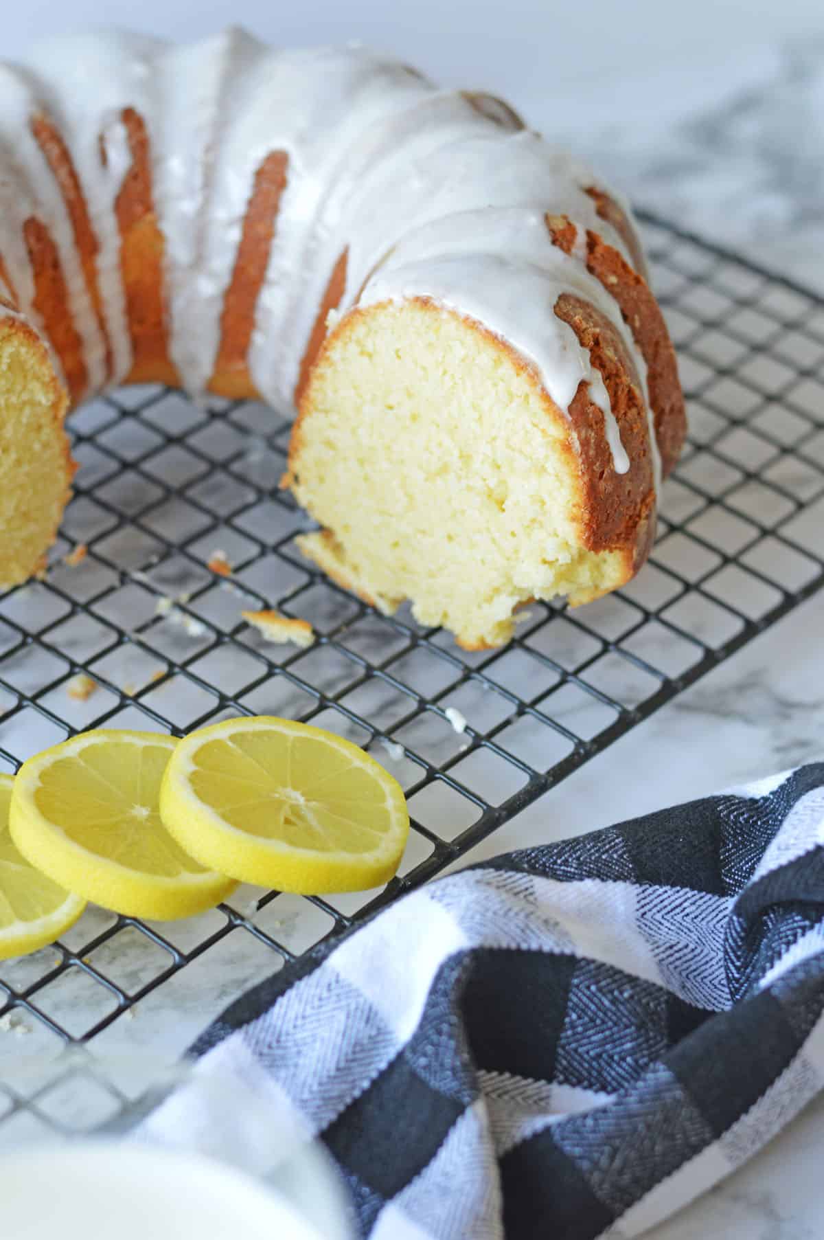 Part of a lemon pound cake on a wire rack.