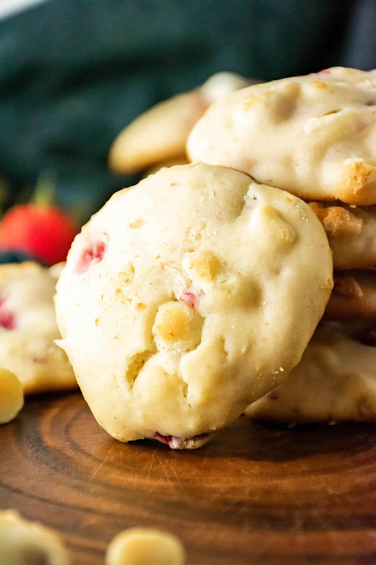 Strawberry cheesecake cookies on a wood slab.