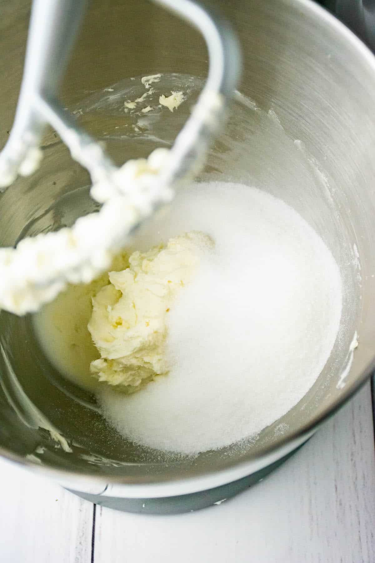 Cream cheese, butter, and sugar in a stand mixer to make strawberry cheesecake cookies.