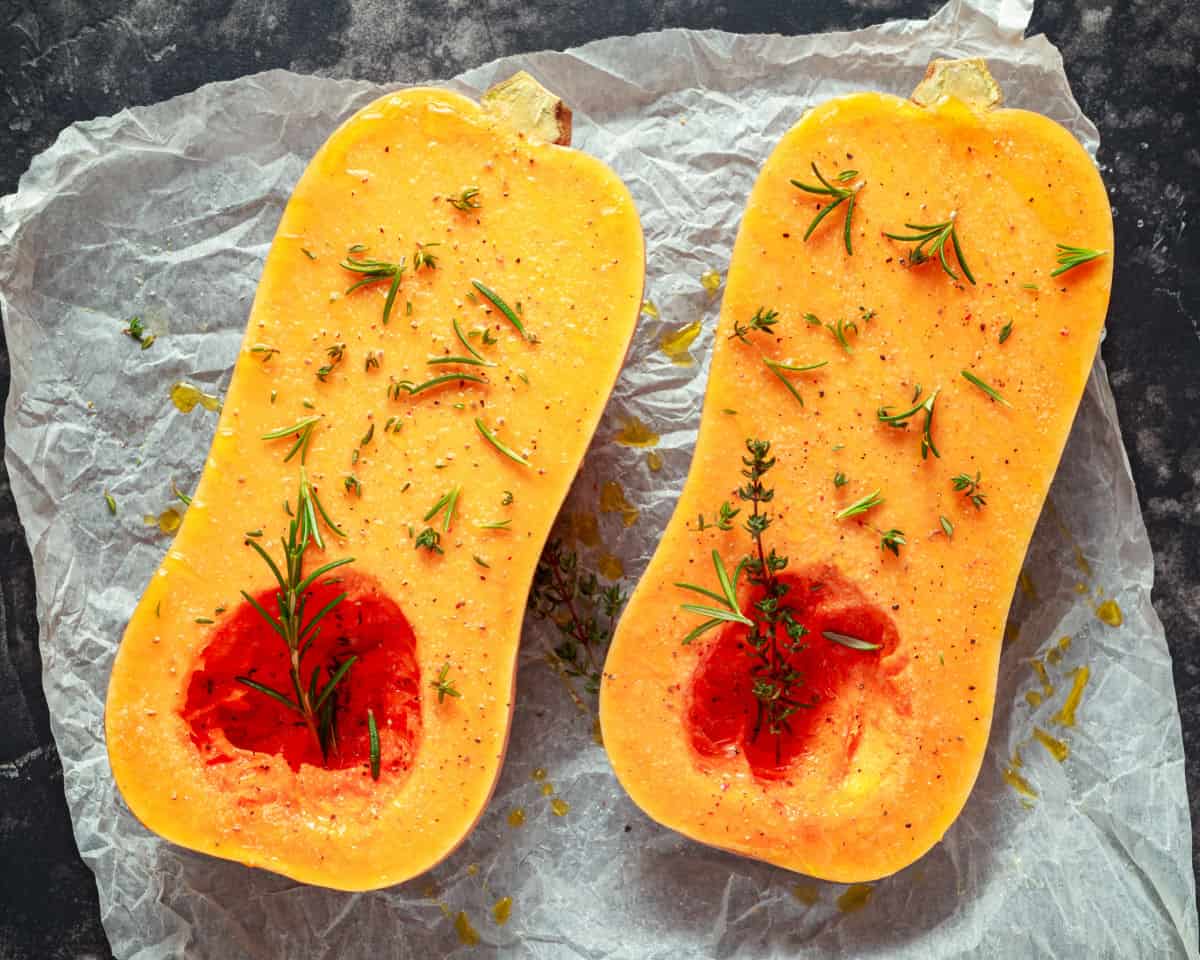 Butternut squash with herbs on parchment paper.