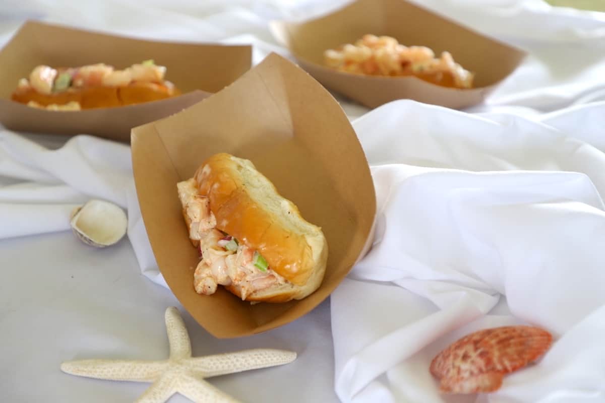 Shrimp salad sandwich on a white background with a starfish in front.