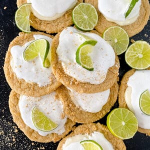 Key lime Crumbl cookies with lime slice on a black table.