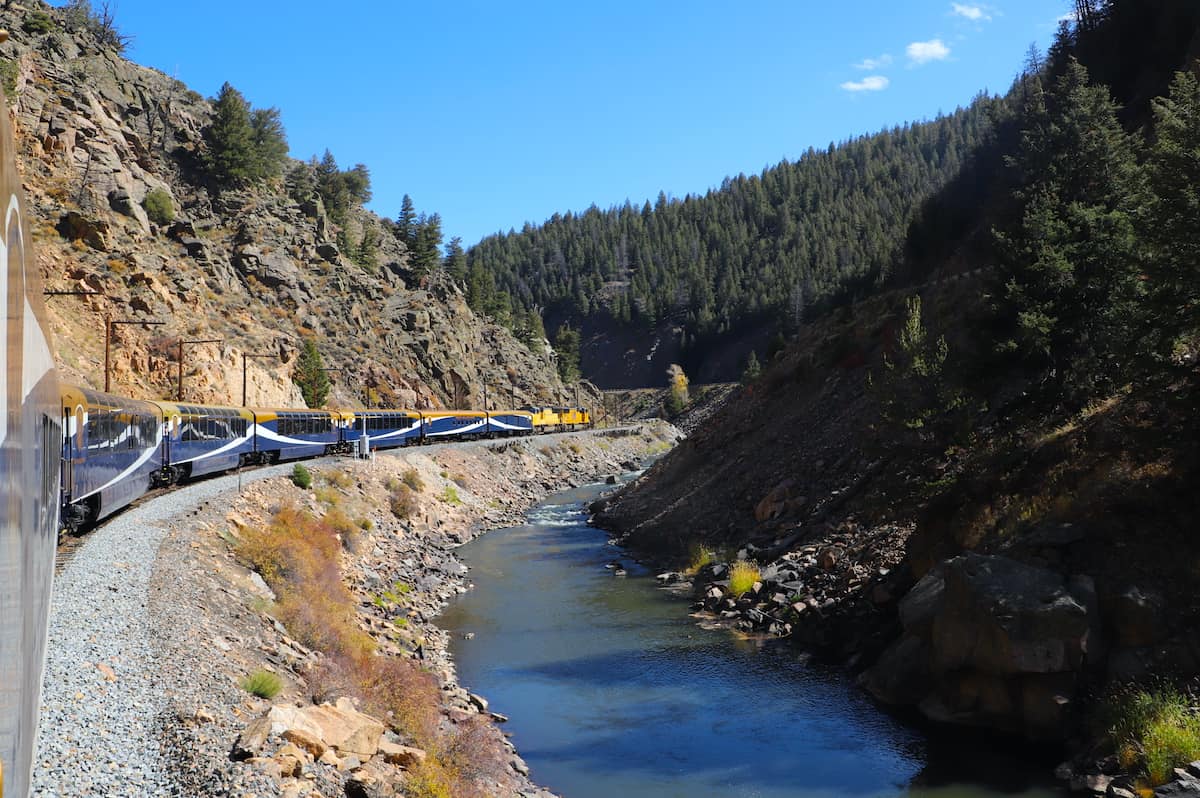 Train alongside river in Colorado.