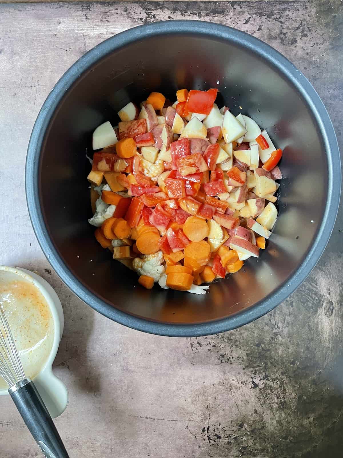 Veggies in slow cooker with sauce poured on top.