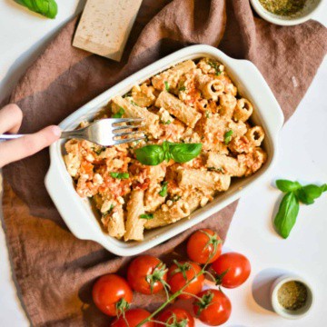 Baked feta pasta recipe with hand and fork.
