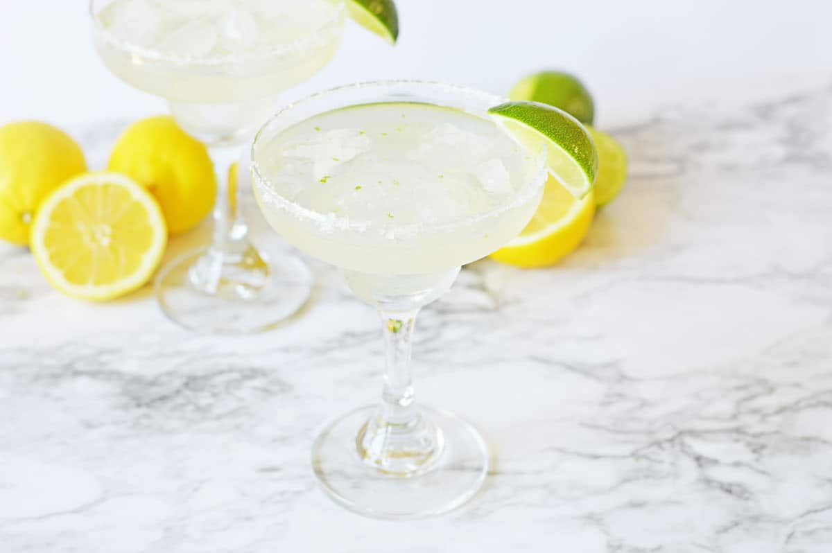 Vodka margarita with a lime wedge on marble counter.