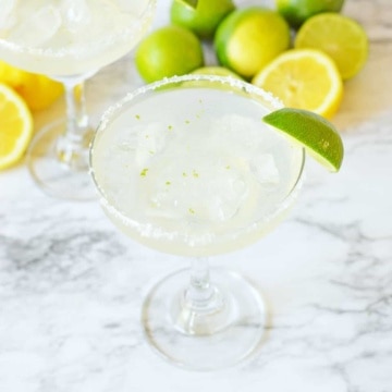 Vodka margarita cocktail in a tall glass with a lime wedge.