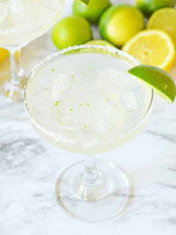 Vodka margarita cocktail in a tall glass with a lime wedge.