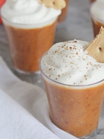 Pumpkin pudding in shot glasses with whipped cream.