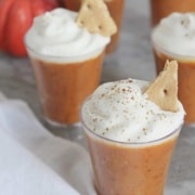 Pumpkin pudding in shot glasses with whipped cream.